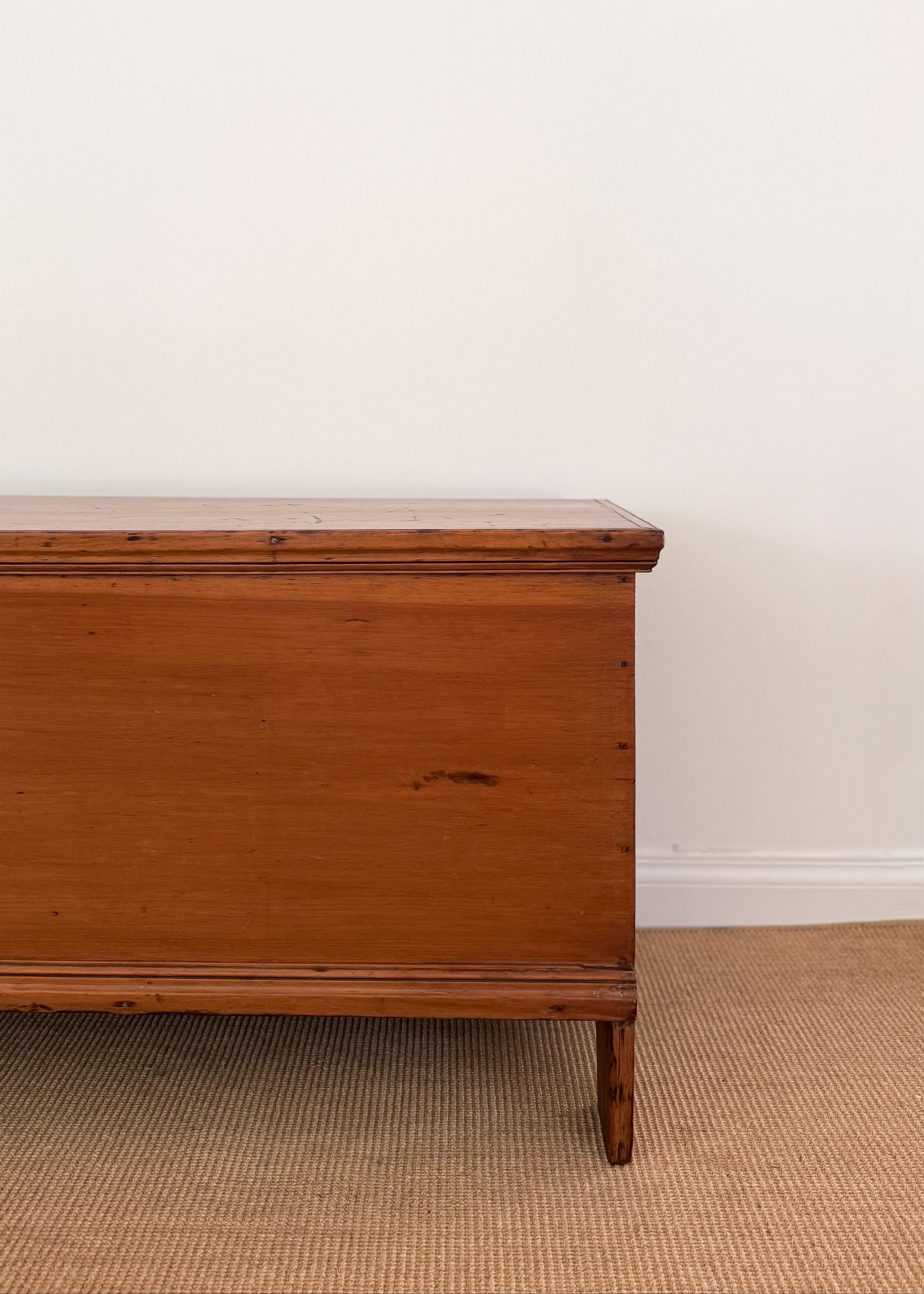 Antique Wooden chest of drawers against a white wall