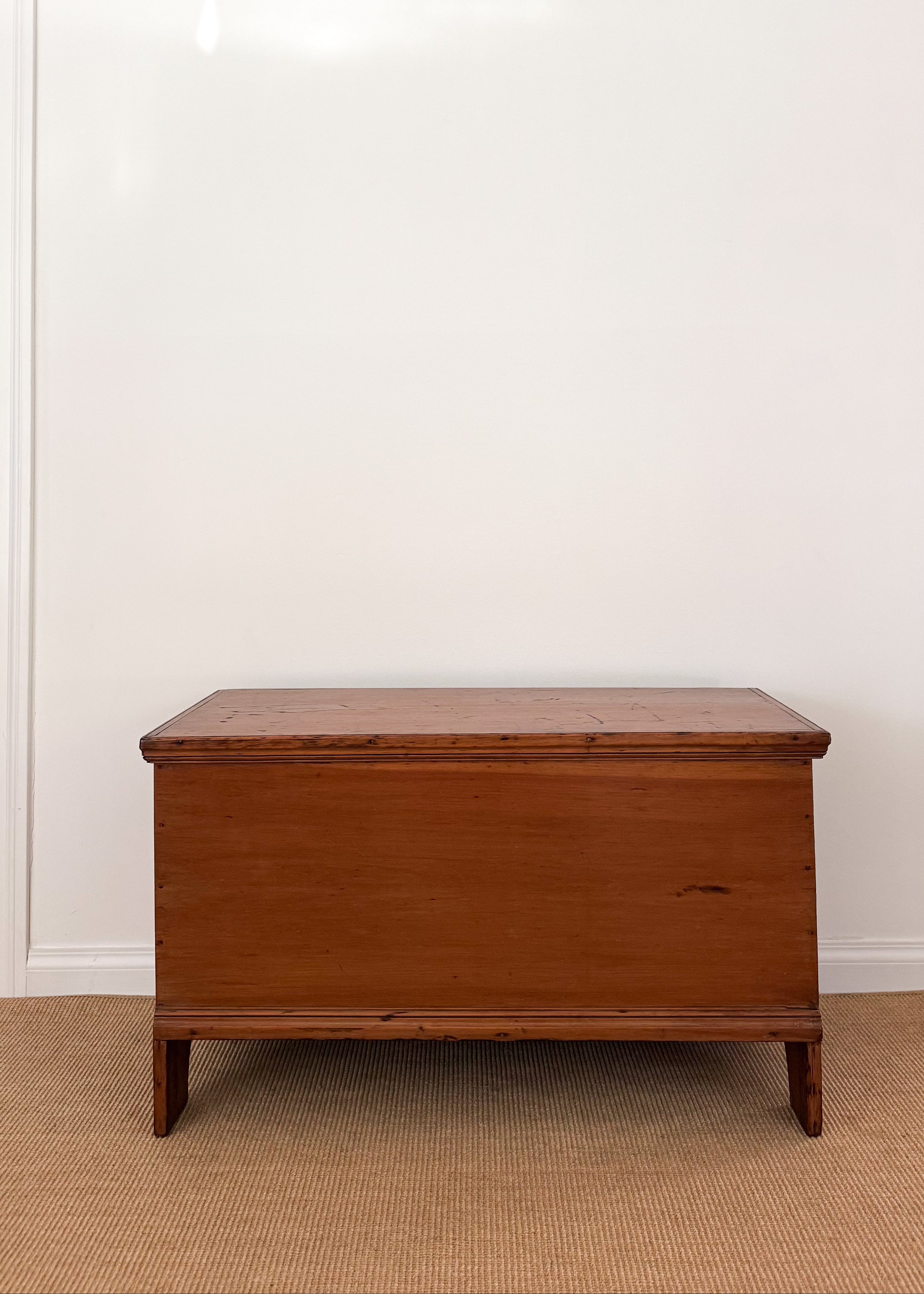 Antique wood chest against a white wall