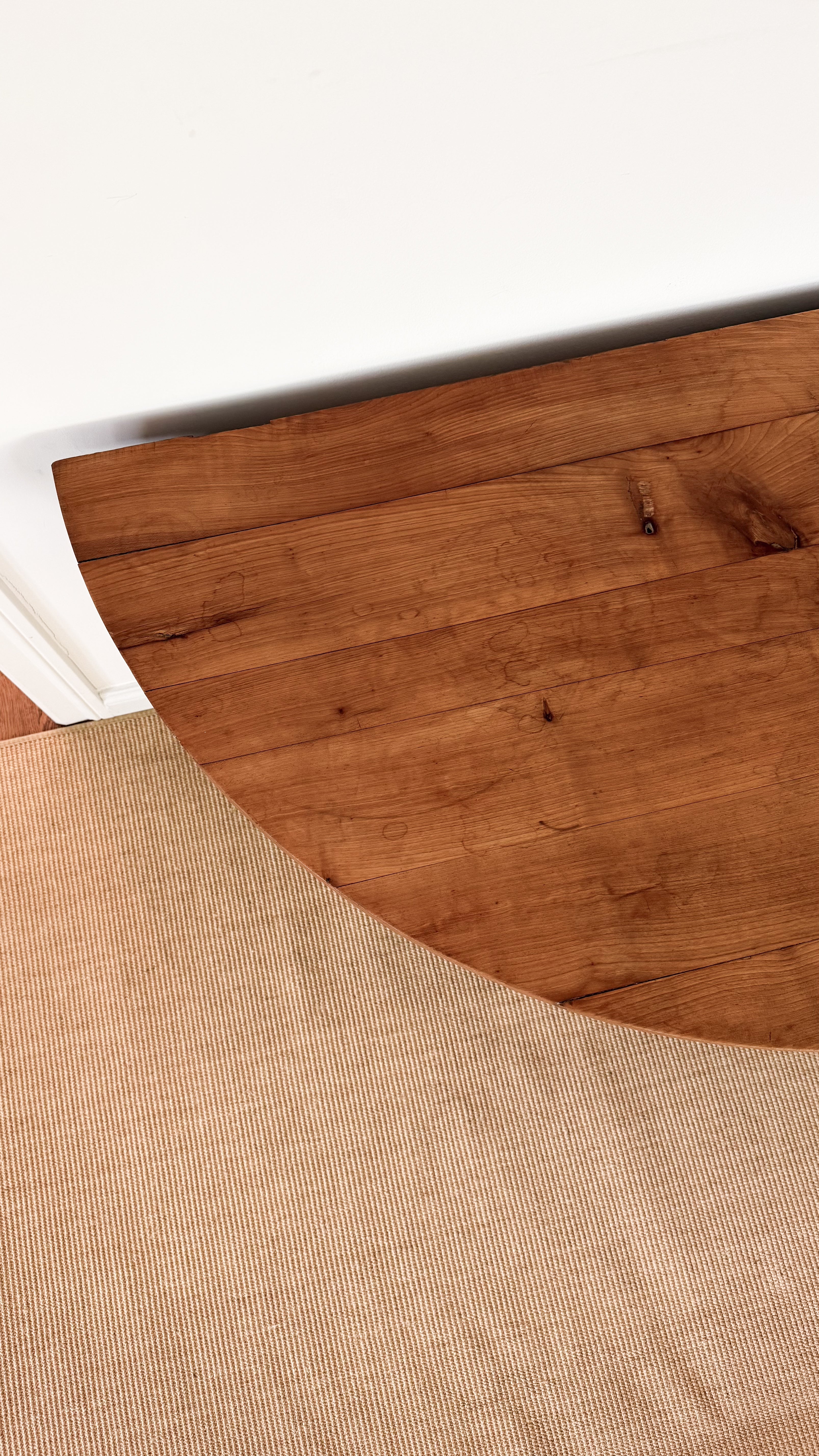 Close-up of a wooden dining table with a textured brown fabric underneath
