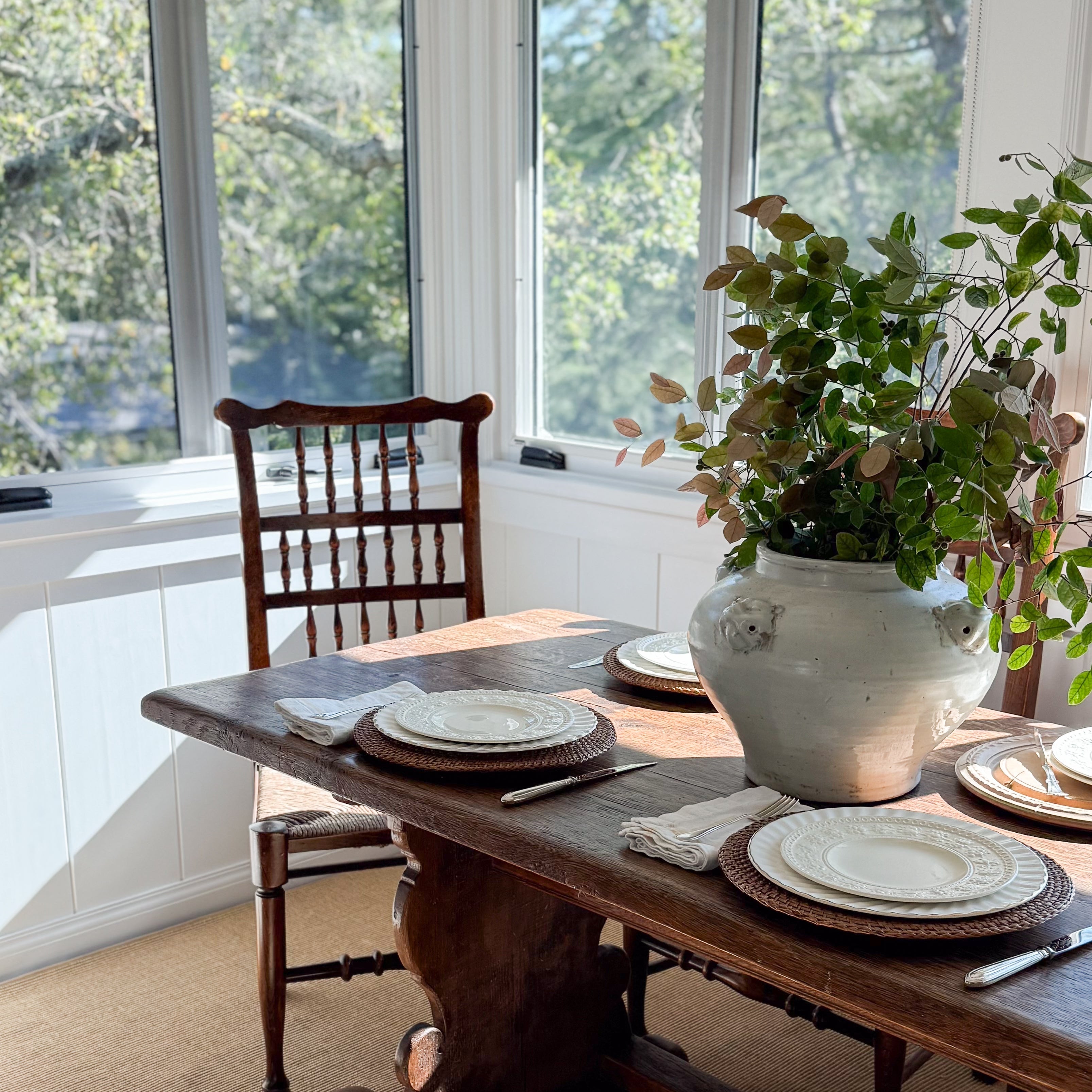 An english solid wood chair and trestle dining table with antique white vase with florals