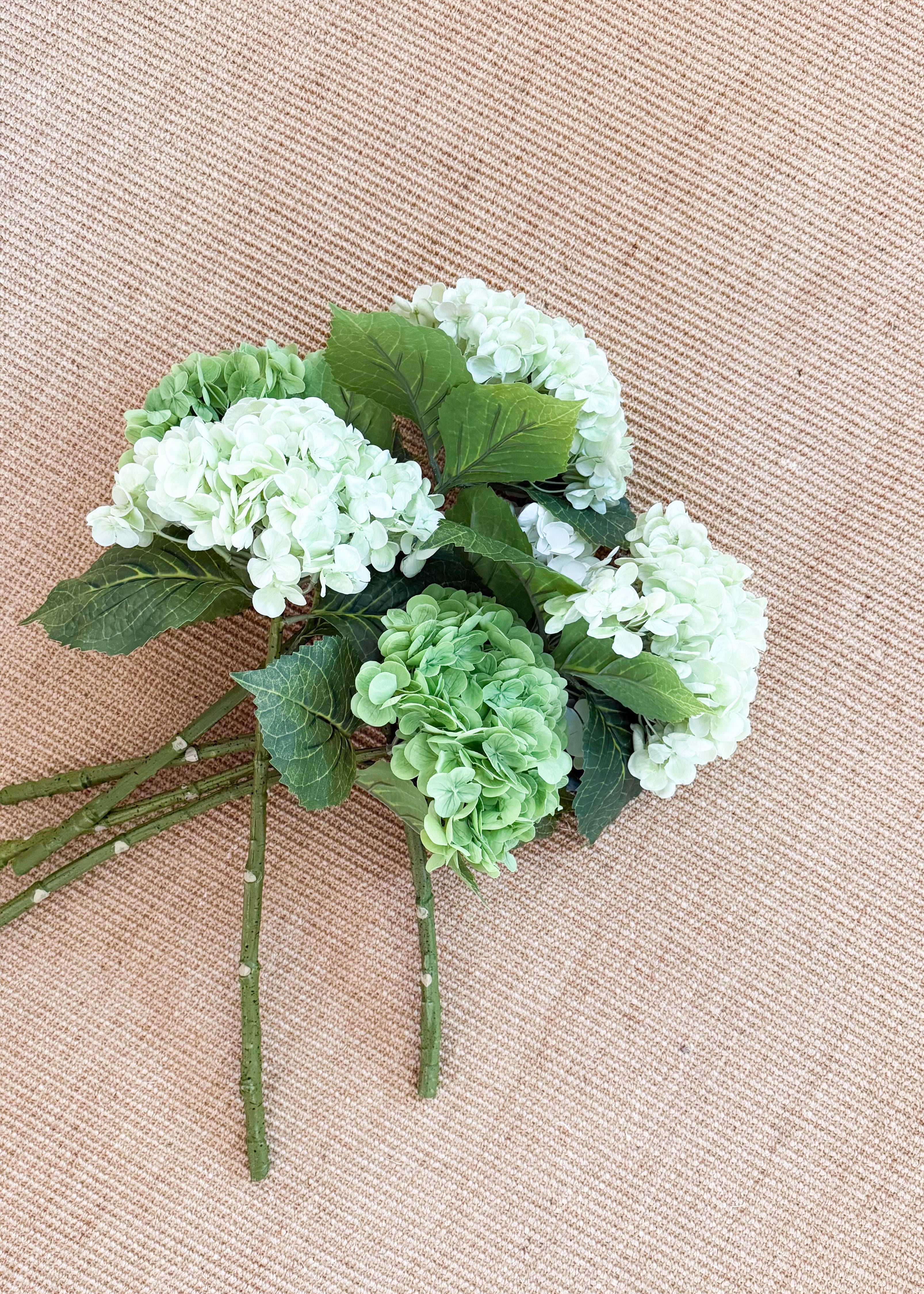 Bouquet of green and white hydrangea on a woven beige rug