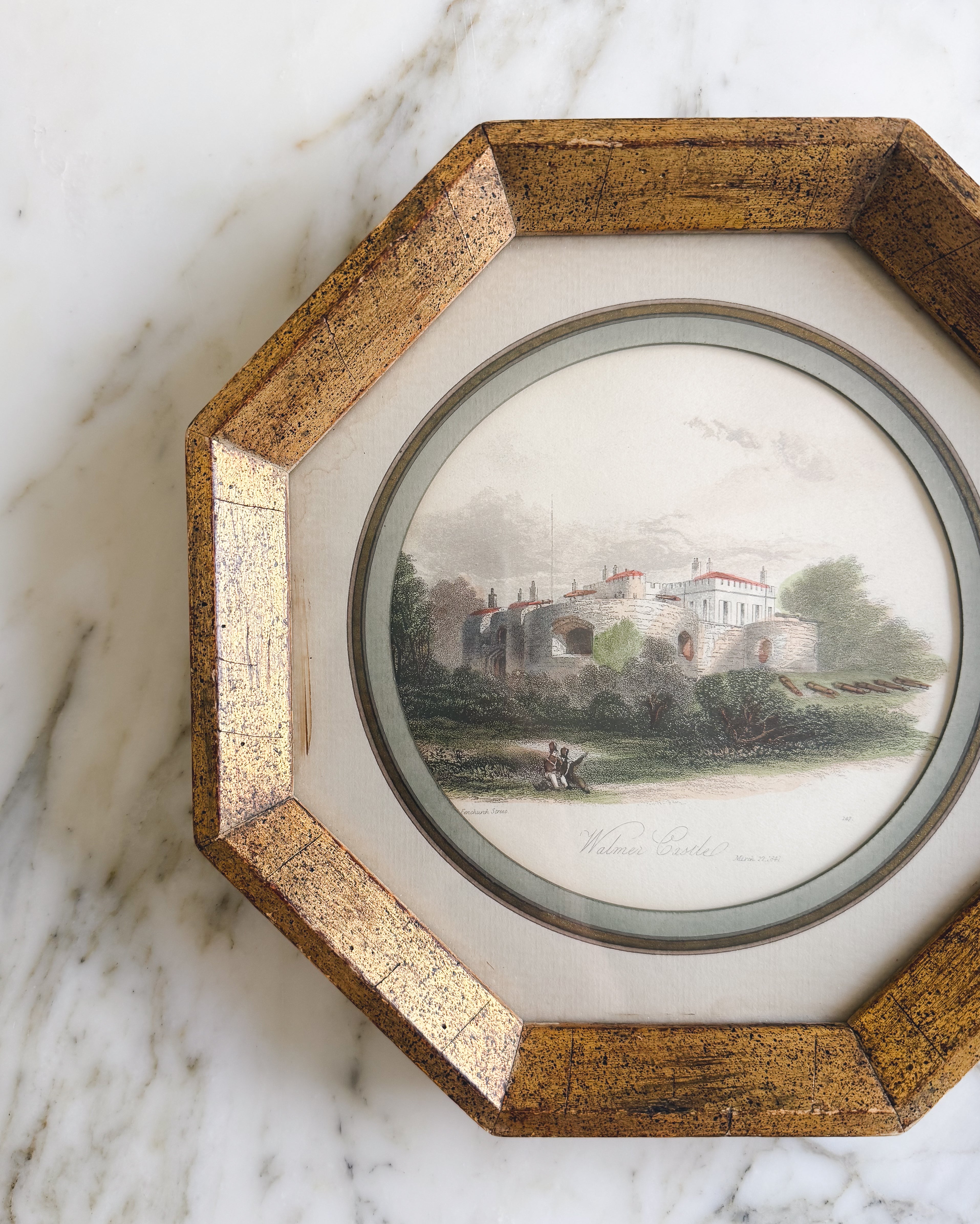 Close up of an antique English hand-colored Walmer Castle engraving in an octagonal gold gilt frame with a sage green mat, dated 1841.
