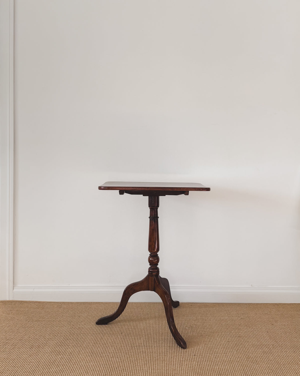 Antique Sheraton mahogany table showing the figured rectangular top, turned pedestal and three graceful legs