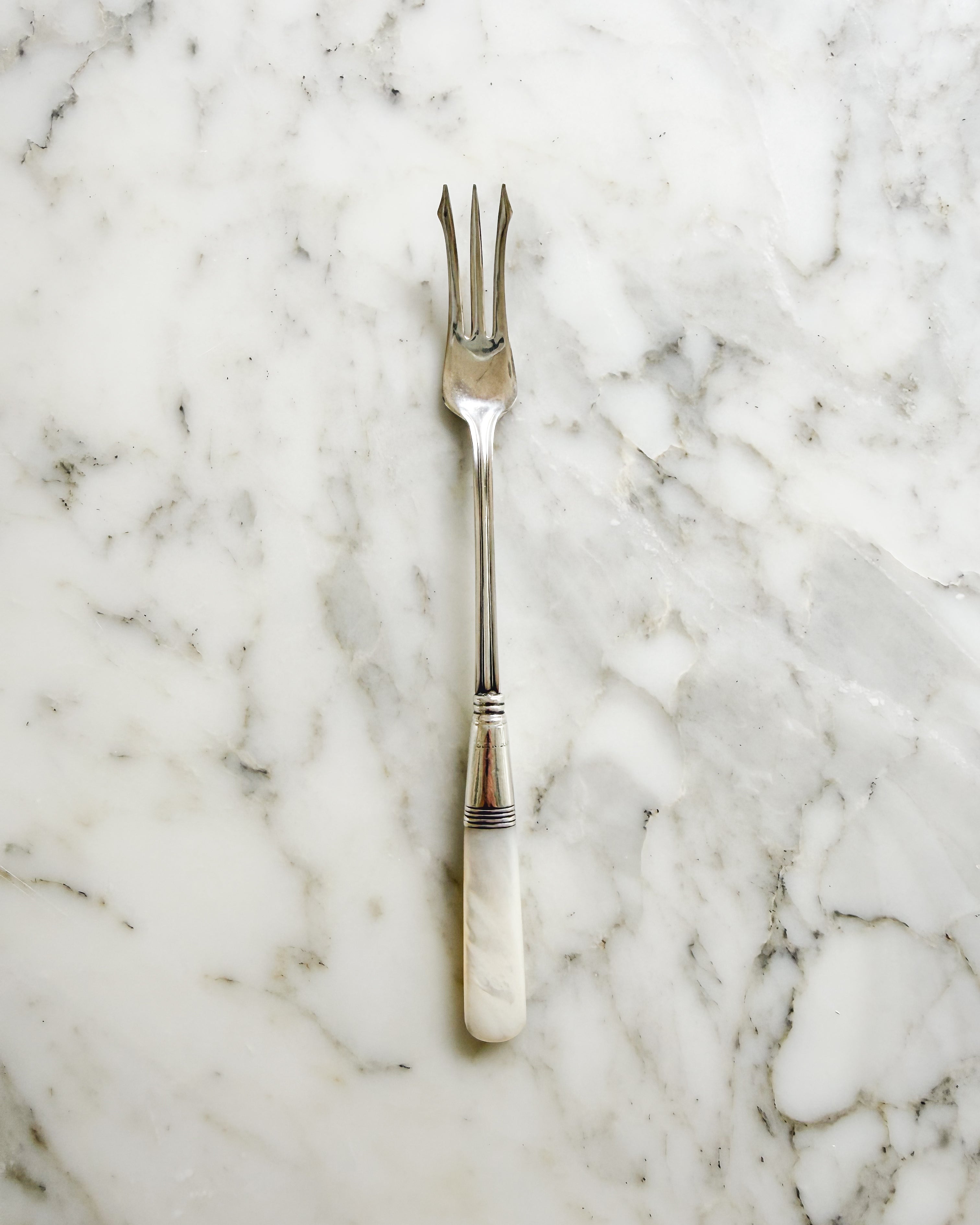 Antique mother of pearl and sterling silver pickle fork.