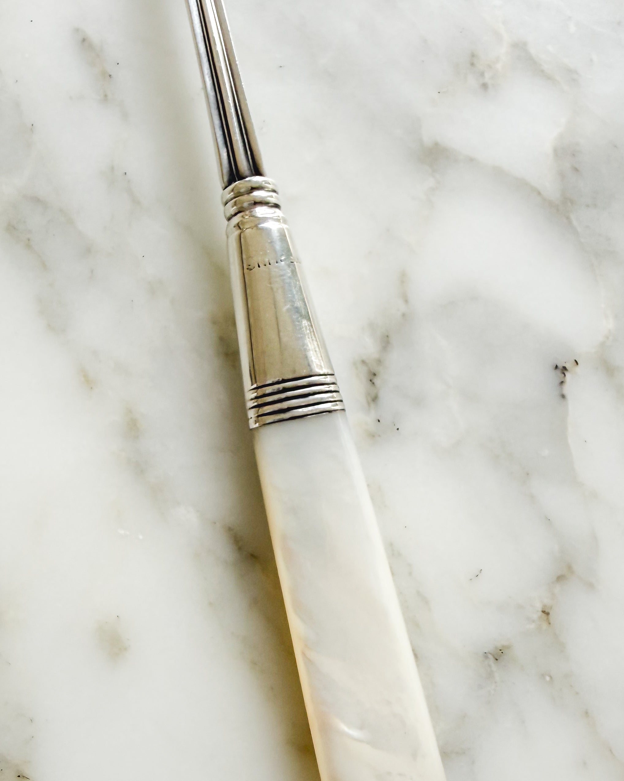 Sterling silver hallmark on antique mother of pearl pickle fork.