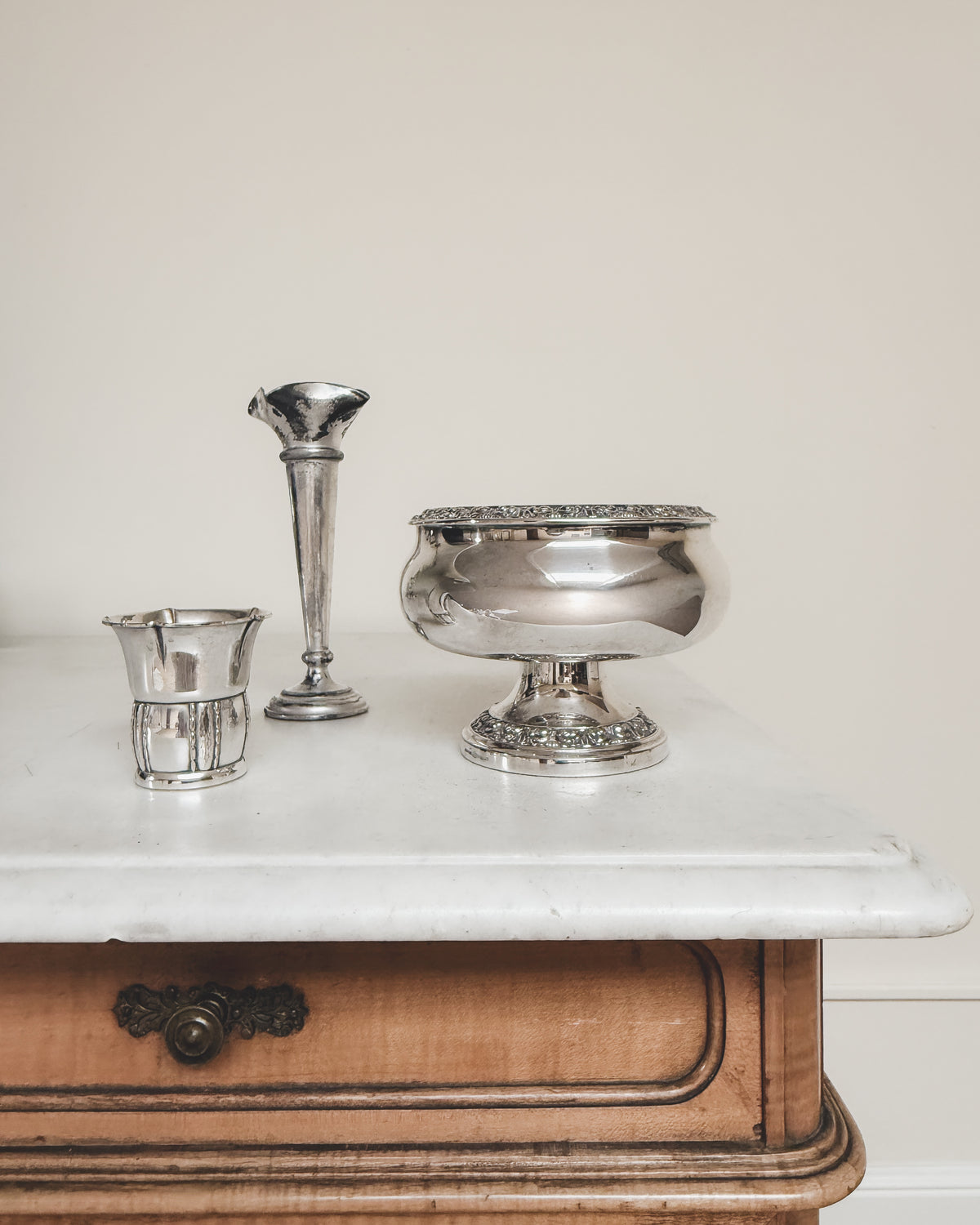 Petite vintage silver vase displayed with a collection of vintage silver vases