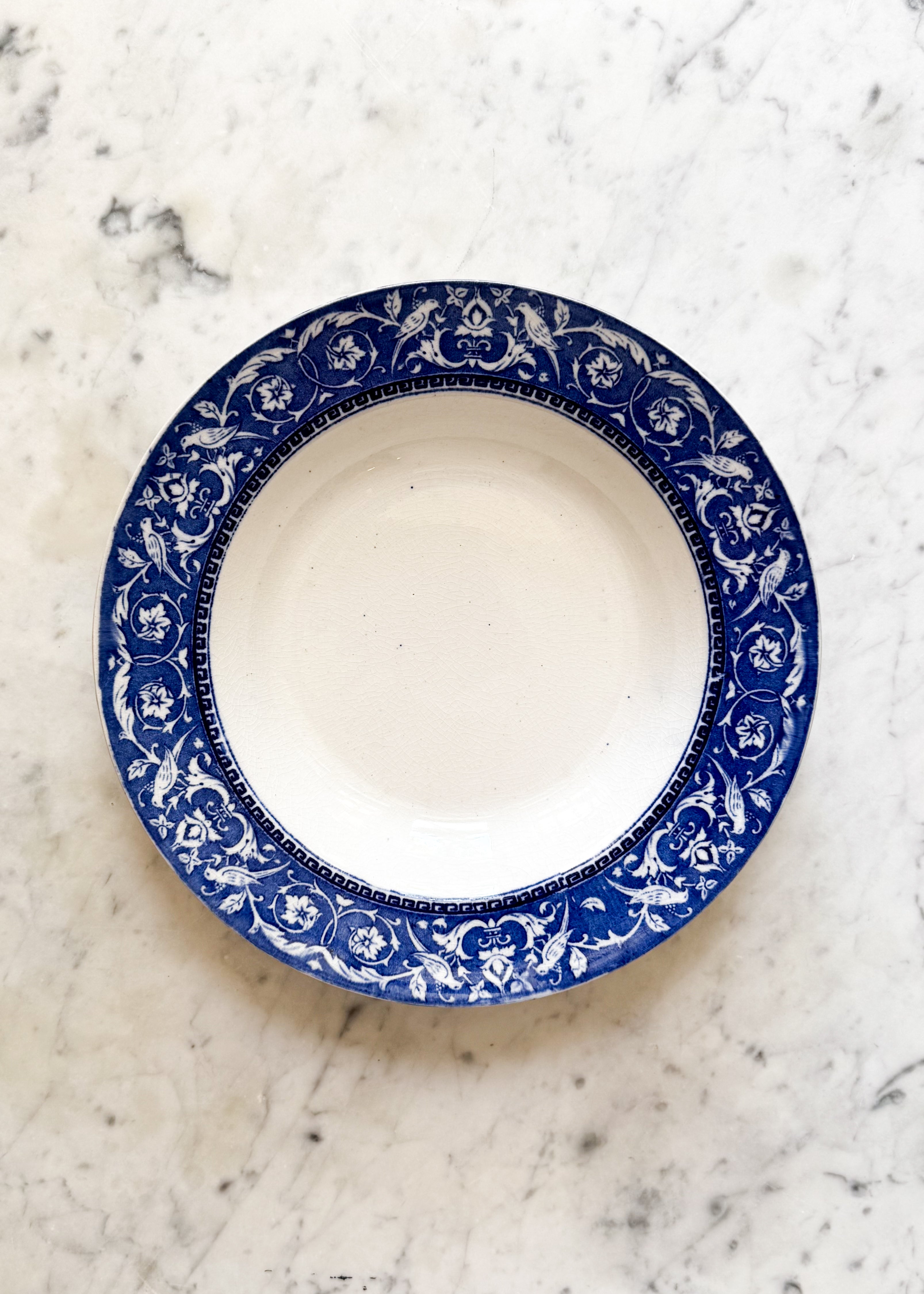 Blue and white rim Antique English Low Bowl on top of a marble counter