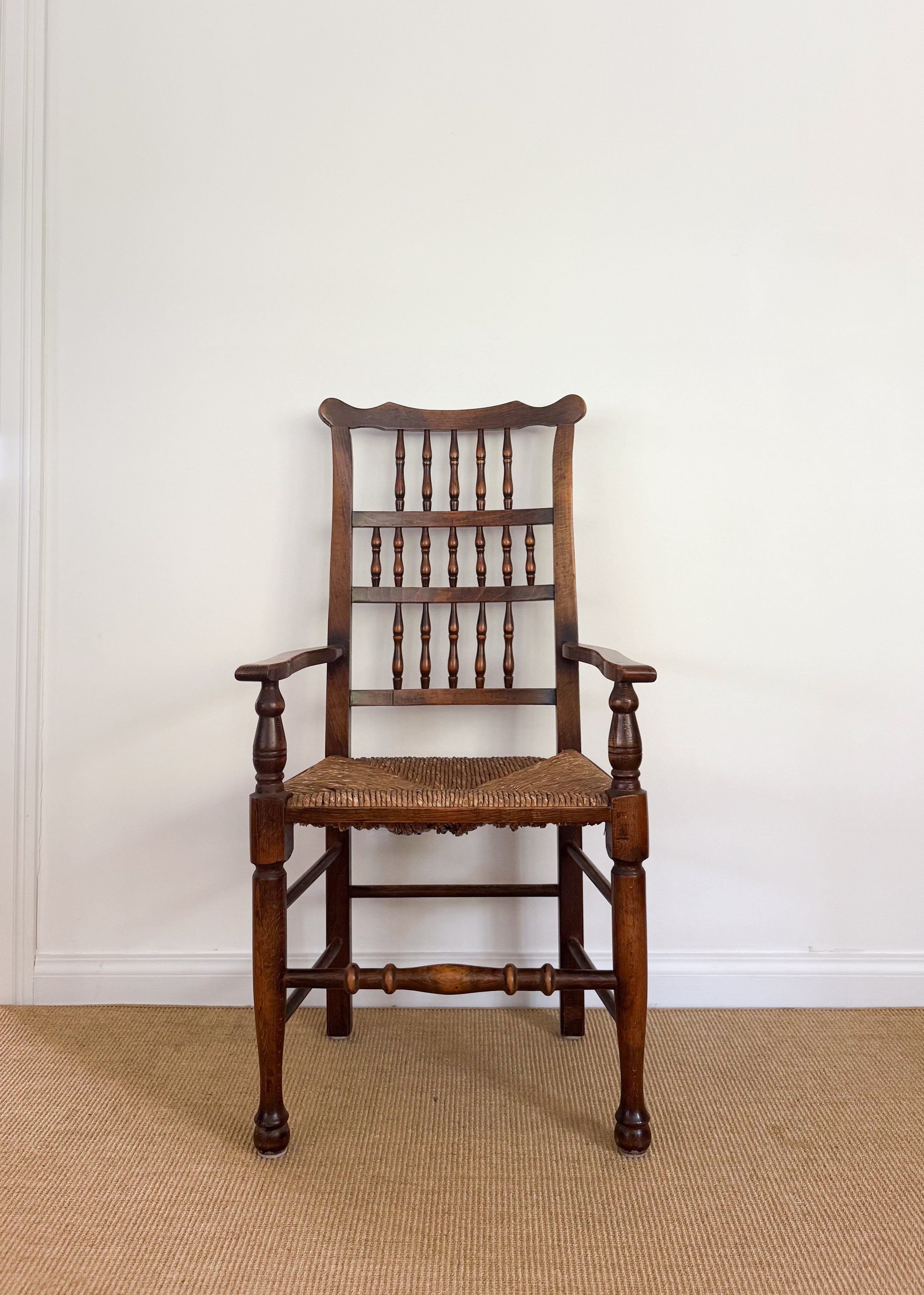 Antique Wooden chair with a woven seat against a white wall