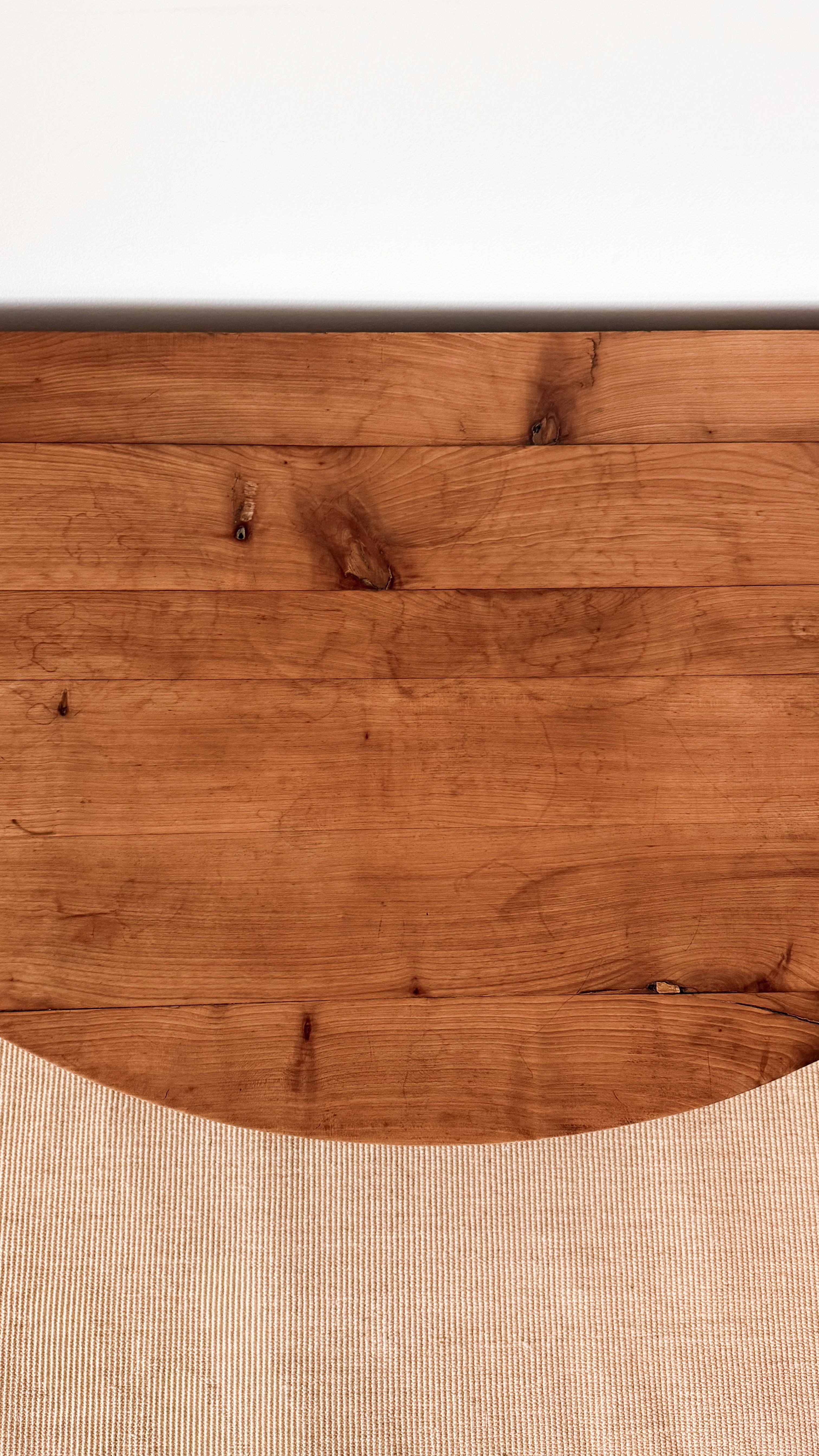 Close-up of a wooden dining table with a white background