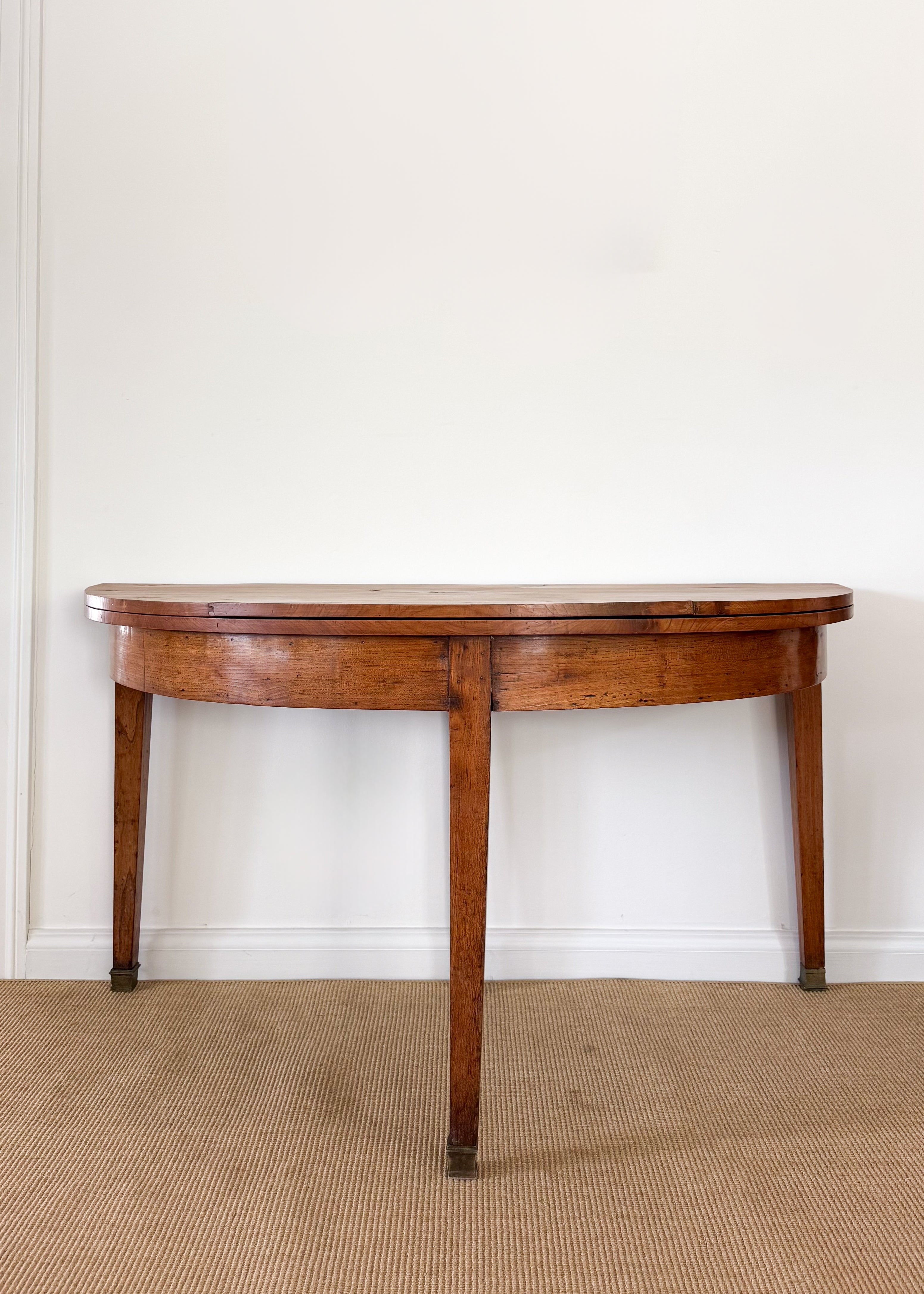 Antique wooden folding dining table against a white wall