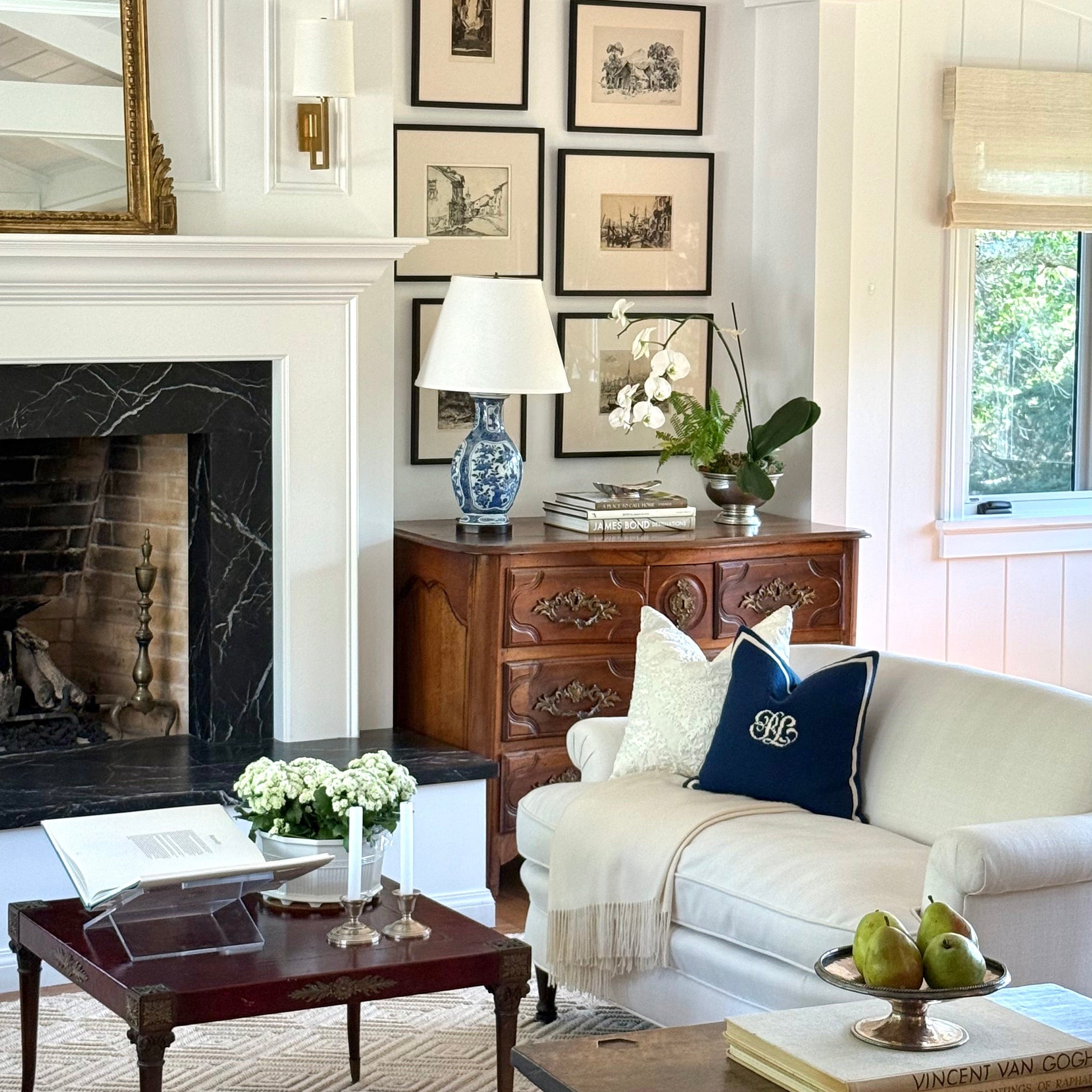 English styled living room with white sofa, wooden coffee table, and fireplace.