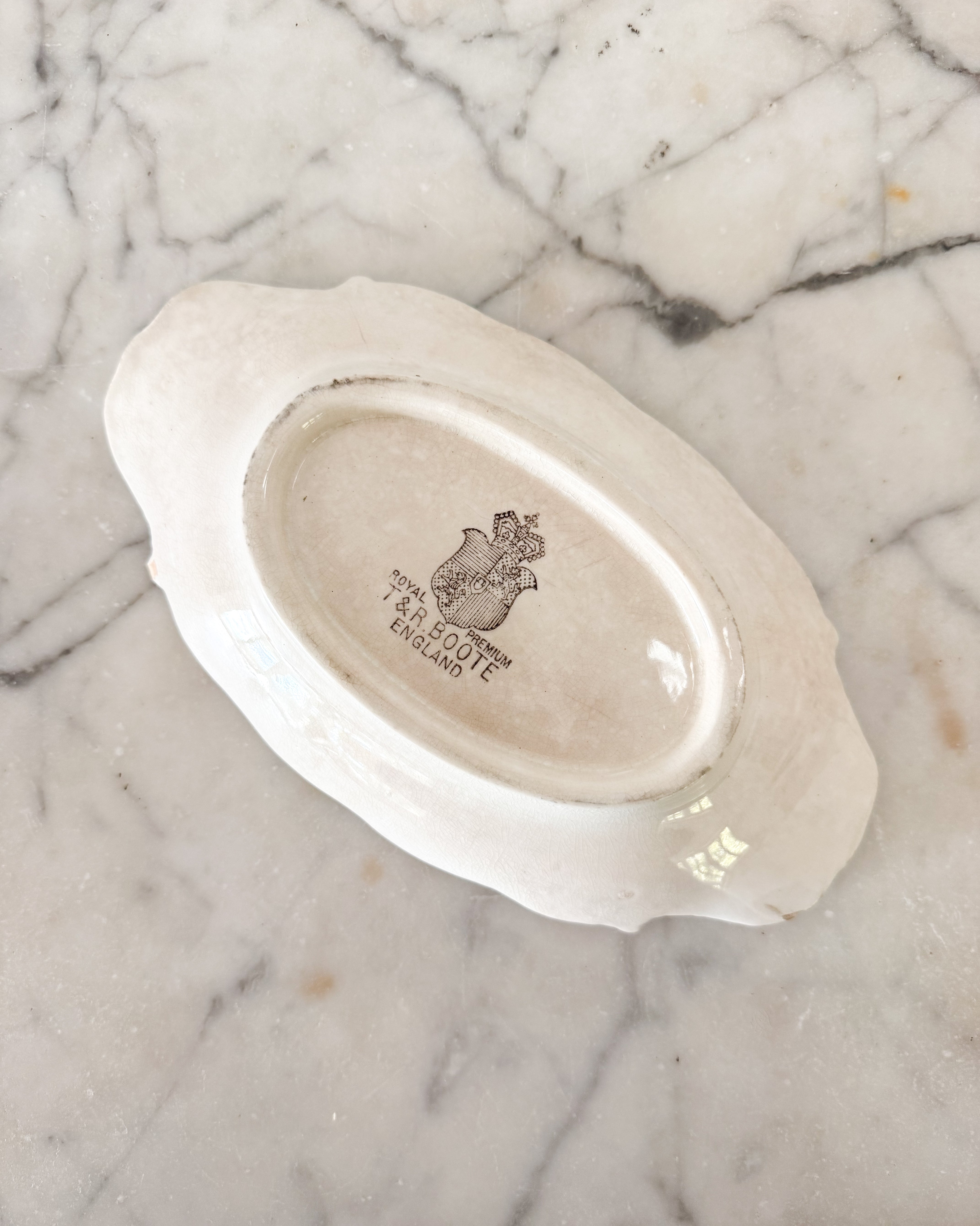 A vintage English ironstone spoonrest shown with maker's mark reading "Royal Premium T&R Boote England."