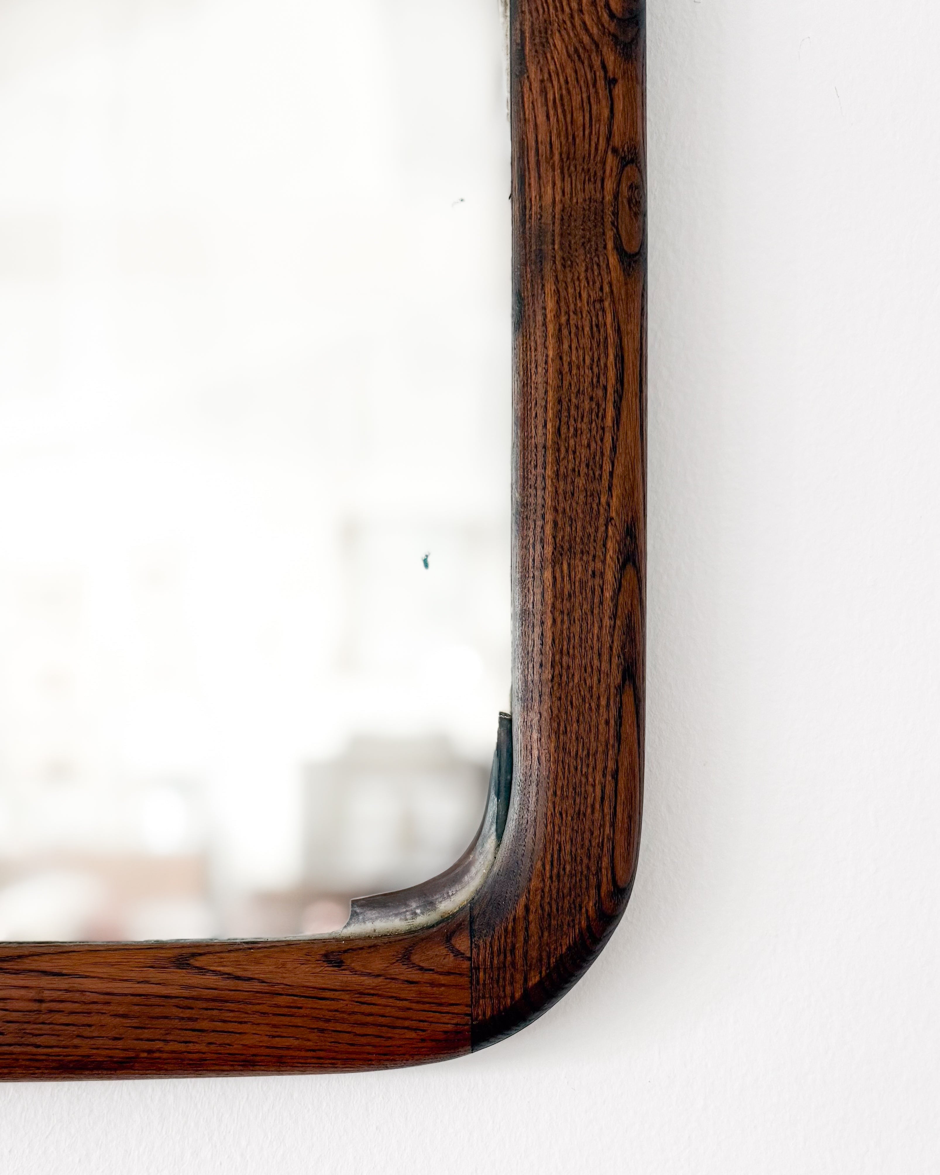 Close-up of the rounded oak corner and original glass on an antique 19th century American oak mirror.