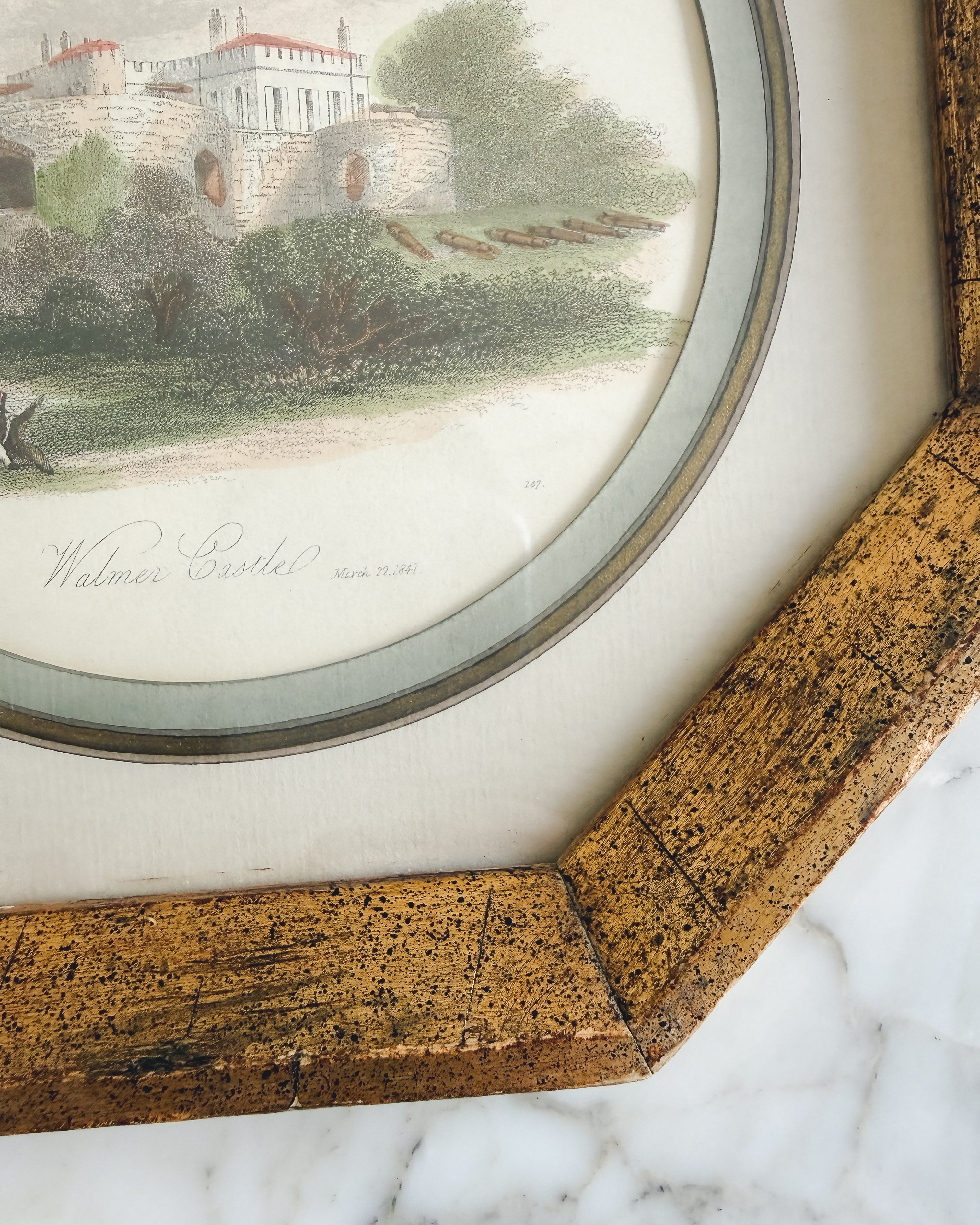 Close-up of an antique English hand-colored Walmer Castle engraving dated 1841 in an octagonal gold gilt frame with a sage green mat.