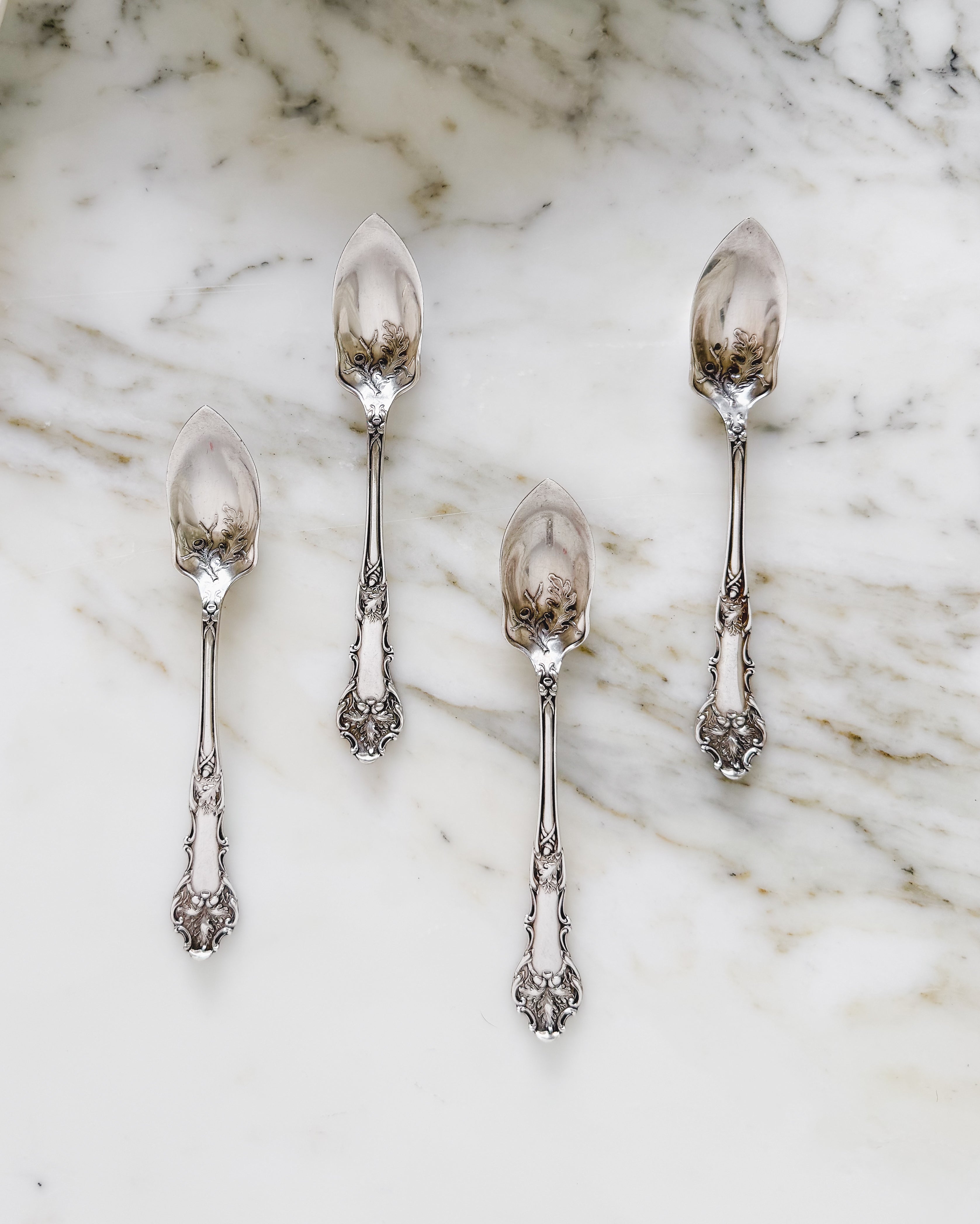 Set of four antique silver plated grapefruit spoons with an oak leaf and acorn pattern.