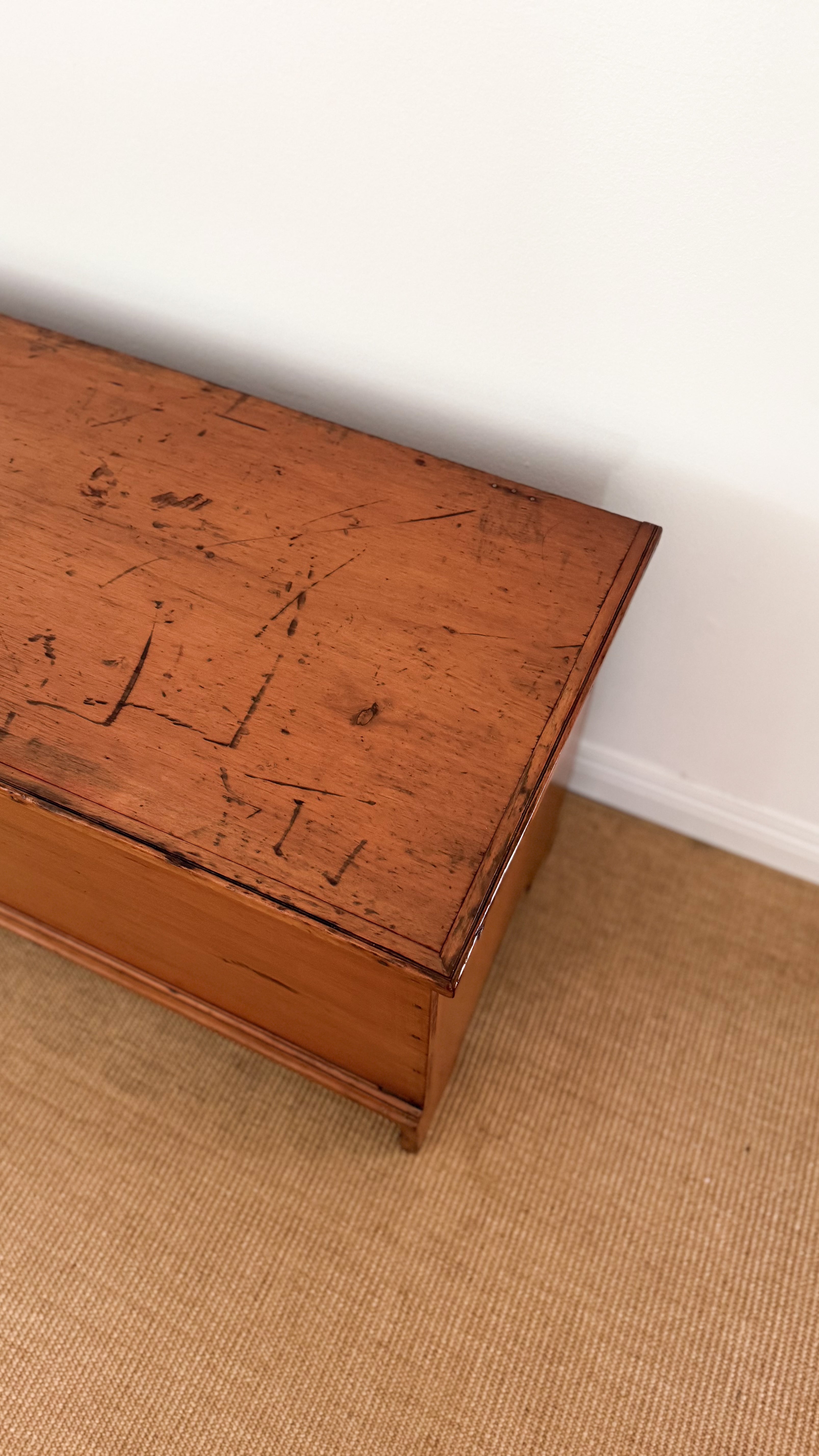 Vintage wooden chest on a beige carpet with a white wall background