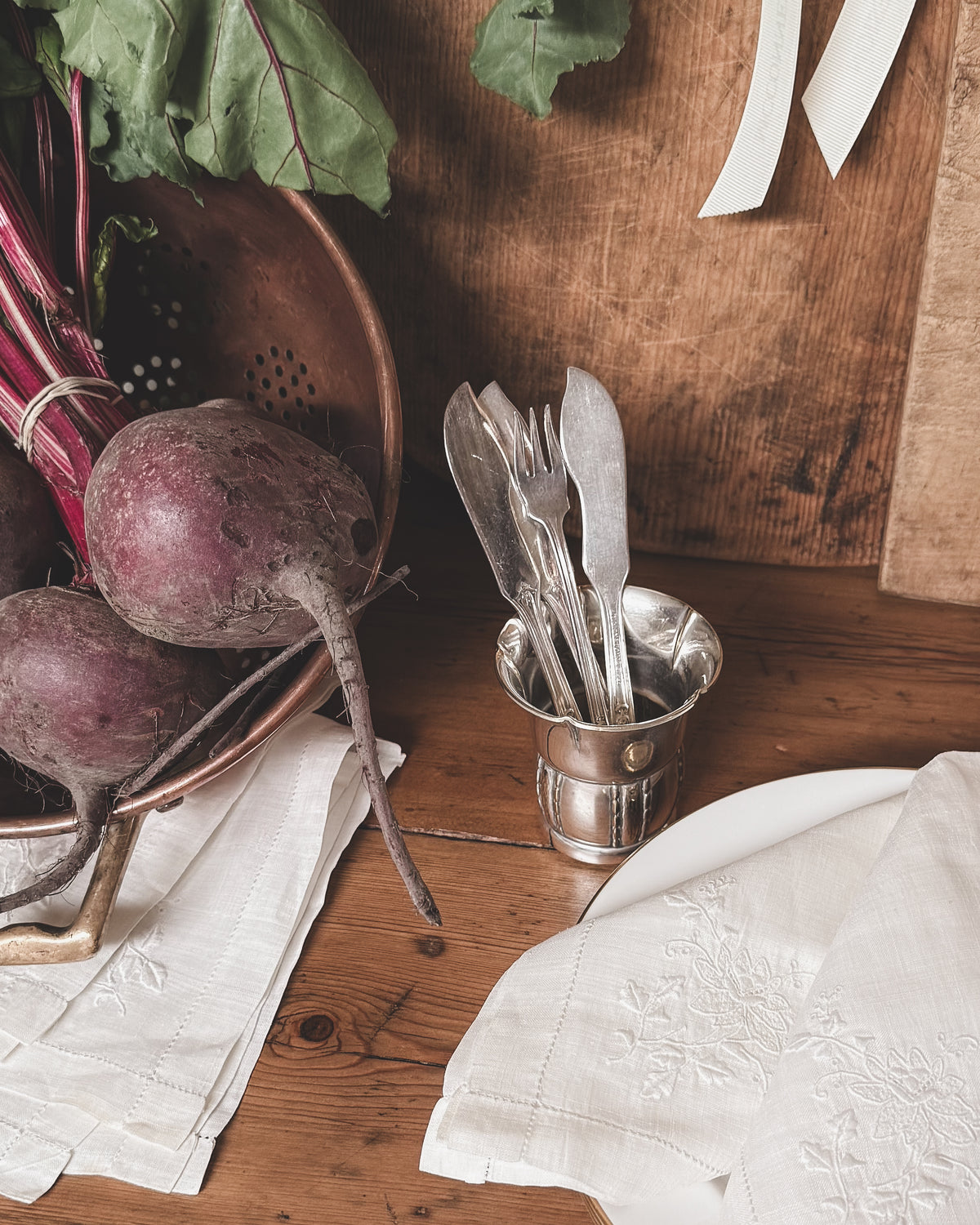 Vintage silver plate petite cup styled with vintage flatware. Shown with vintage embroidered napkins, vintage european bread boards. 